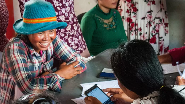 Healthcare worker uses mobile technology during visit with community member.